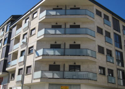 edificio con balcones de cristal y perfil de aluminio